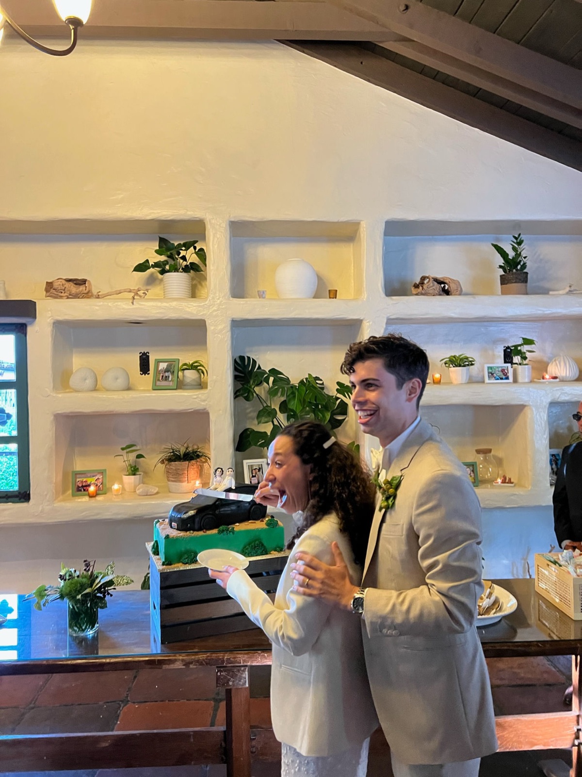 The couple cutting their cake as guests look on